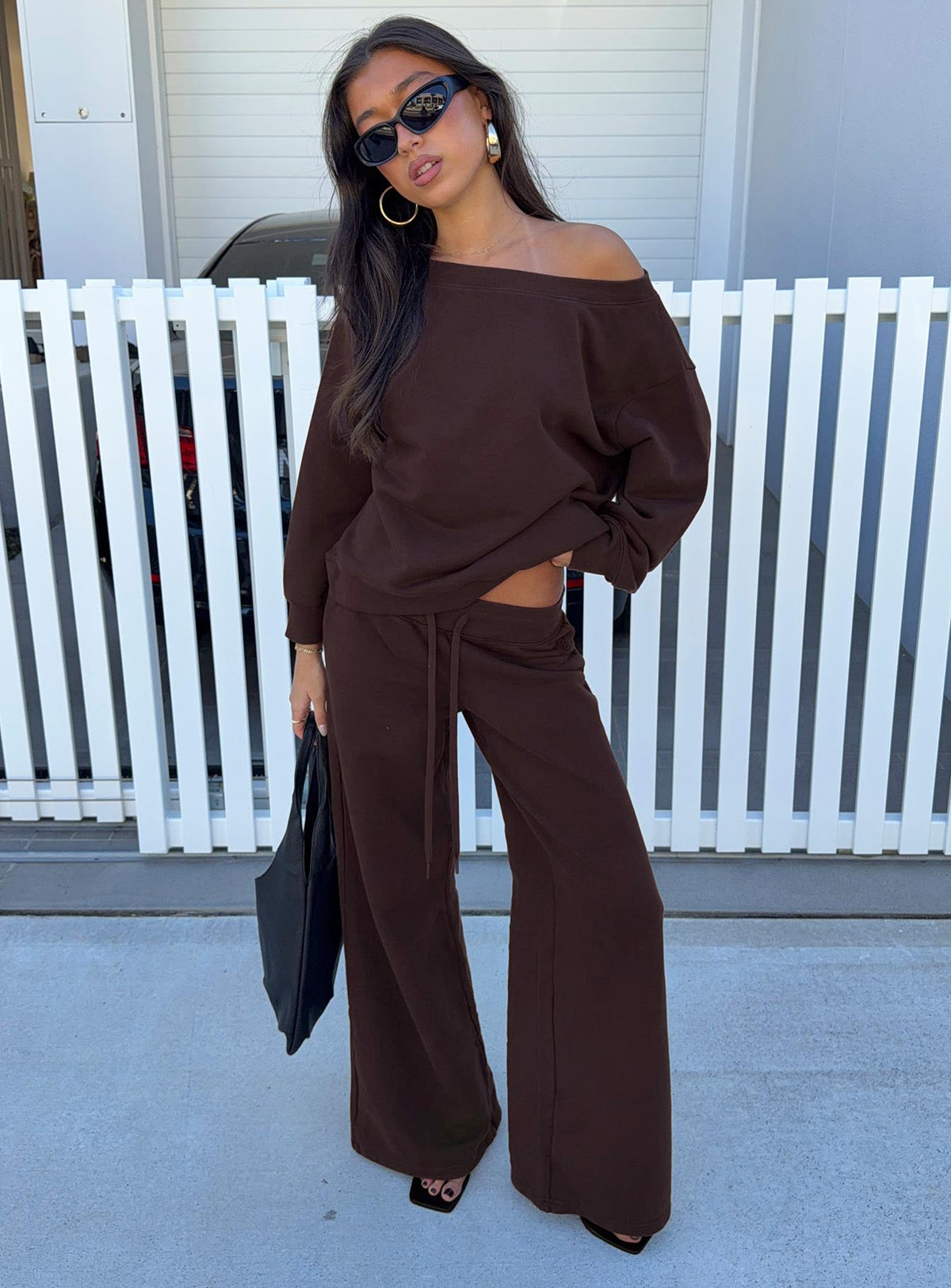 Showcasing the Wellness Off The Shoulder Jumper Brown in women's jumpers with long length and oversized fit front view of model wearing Princess Polly