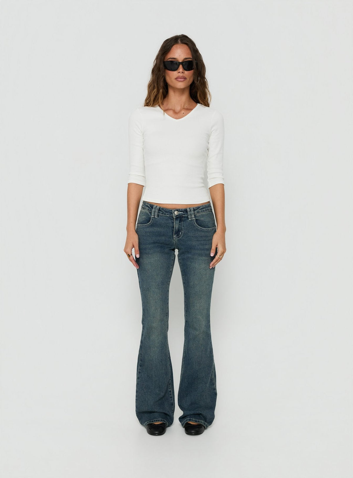 Crafted from low-rise denim, the Clynee Ultra Low Rise Bootleg Jeans Dirty Blue in womens-jeans front view of model wearing Princess Polly