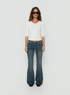 Crafted from low-rise denim, the Clynee Ultra Low Rise Bootleg Jeans Dirty Blue in womens-jeans front view of model wearing Princess Polly