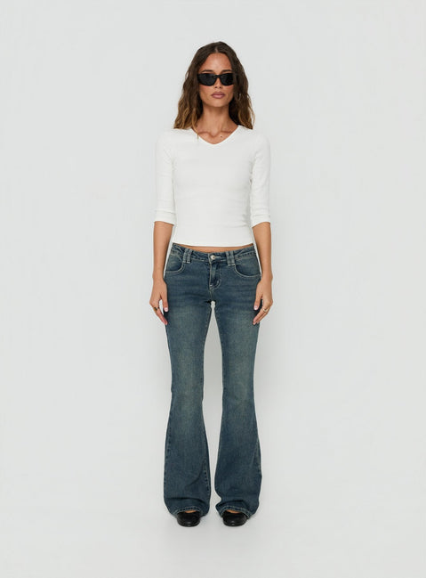 Crafted from low-rise denim, the Clynee Ultra Low Rise Bootleg Jeans Dirty Blue in womens-jeans front view of model wearing Princess Polly
