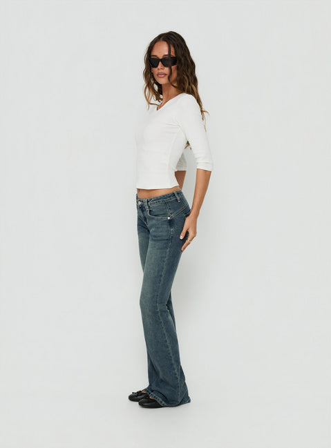 Presenting the Clynee Ultra Low Rise Bootleg Jeans Dirty Blue in womens-jeans with low-rise waist side view of model wearing Princess Polly