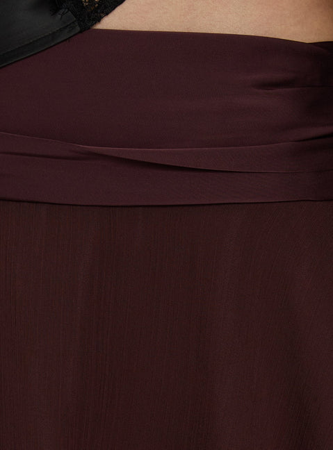 Featuring the Emey Asymmetrical Mini Skirt Brown womens-skirts in solid maroon with flared hem details Princess Polly