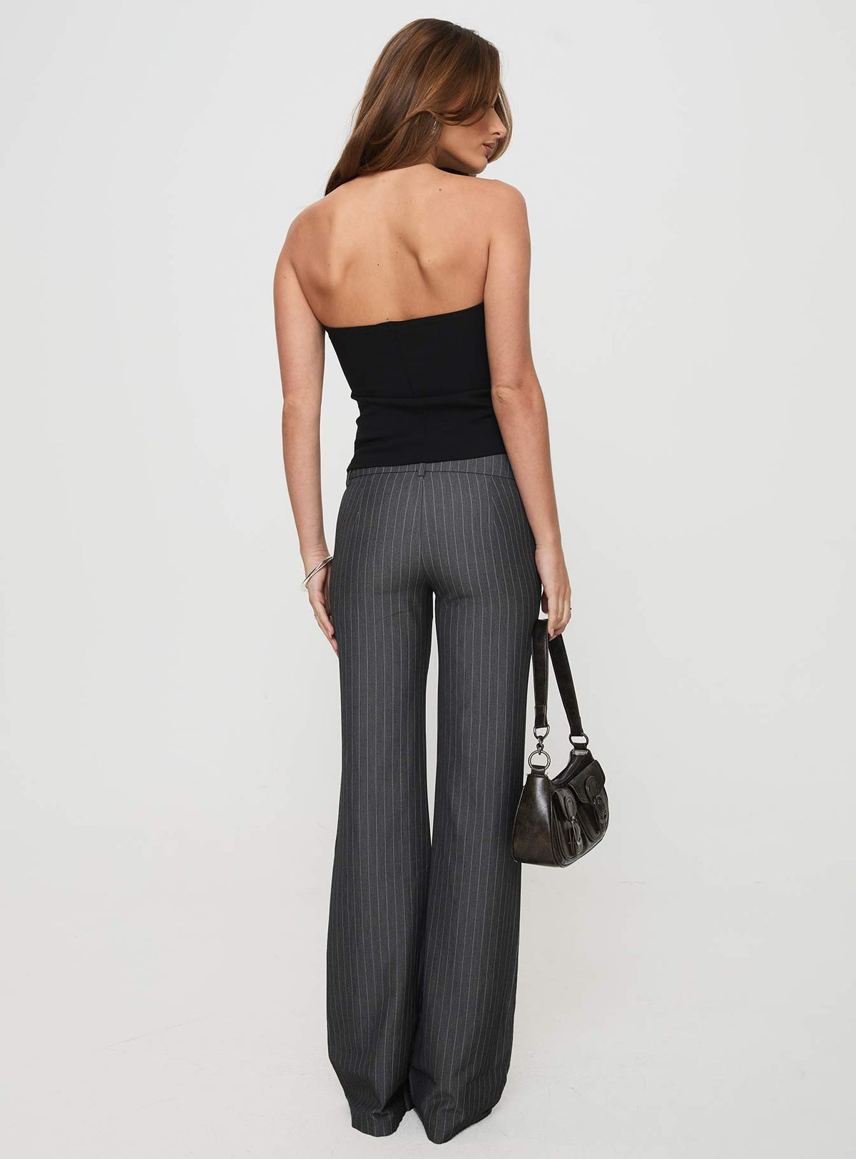 back view of model wearing Princess Polly Kinkirk Flared Pants Grey Pinstripe Petite 