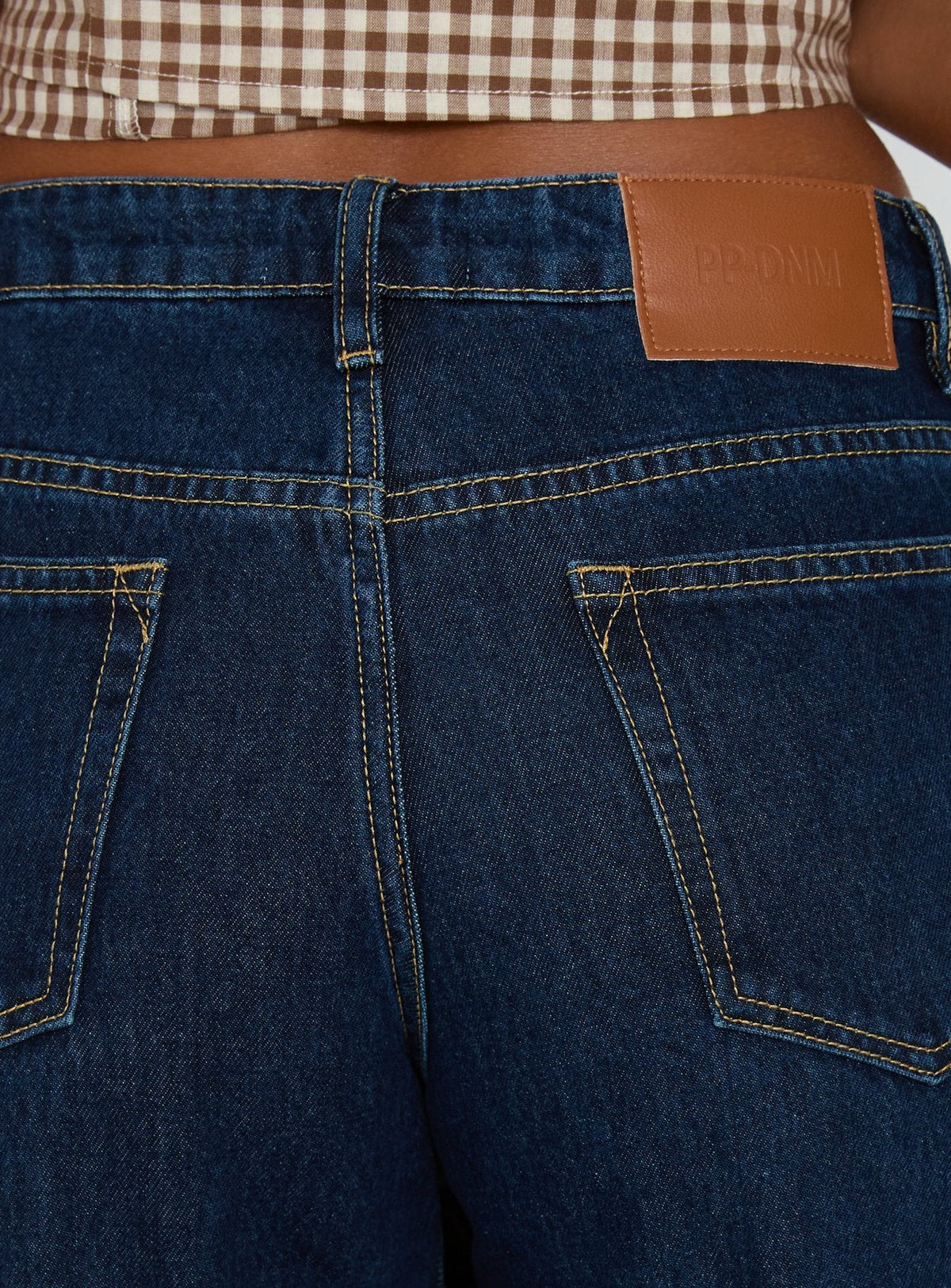 back view of model wearing Princess Polly Darla Low Rise Straight Leg Cuff Jean Dark Blue Wash Low Rise Jeans Jeans 