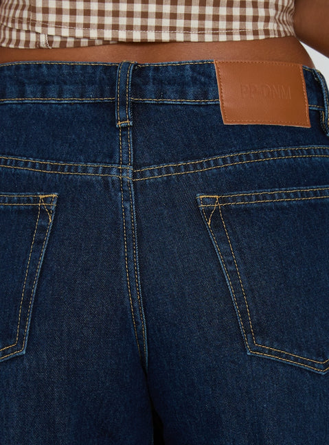 back view of model wearing Princess Polly Darla Low Rise Straight Leg Cuff Jean Dark Blue Wash Low Rise Jeans Jeans 