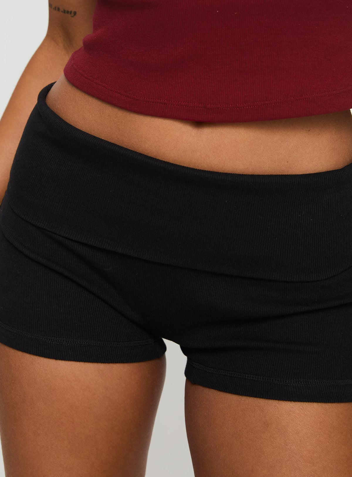 side view of model wearing Princess Polly Baseline Low Rise Rib Shorts Black High Waisted Shorts 