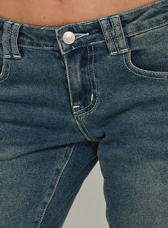 Highlighting the Clynee Ultra Low Rise Bootleg Jeans Dirty Blue in womens-jeans with low-rise waist Princess Polly