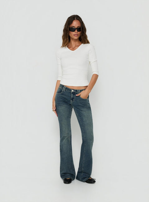 Crafted from low-rise denim, the Clynee Ultra Low Rise Bootleg Jeans Dirty Blue in womens-jeans front view of model wearing Princess Polly